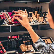 Donna afferra un rossetto dagli scaffali di un negozio