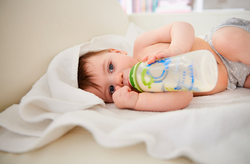 Bambino di pochi mesi beve latte da un Biberon con Stampa Personalizzata